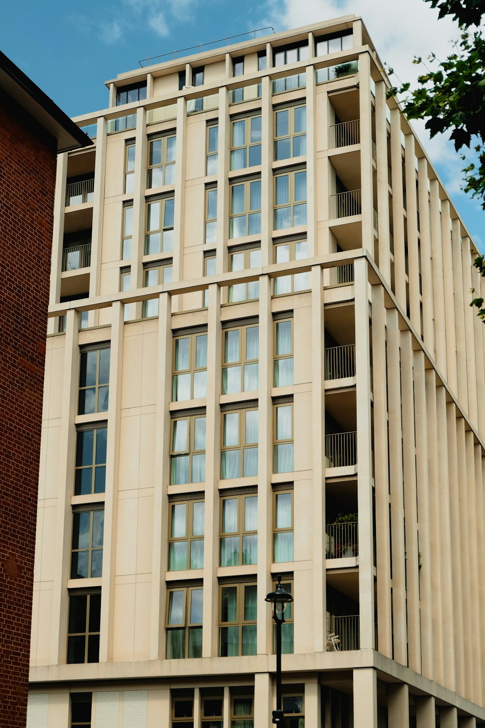 a tall building with lots of windows next to a tree