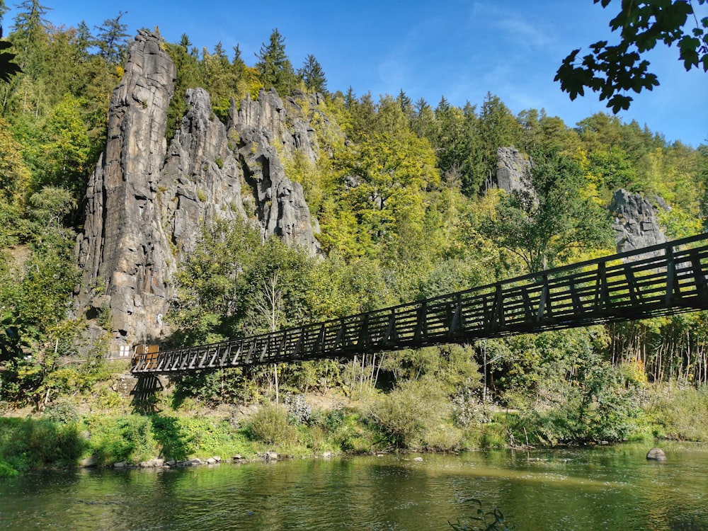 a bridge over a river with a mountain in the background