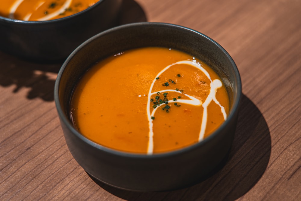 two bowls of soup on a wooden table