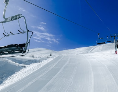 a ski lift going up a snowy hill