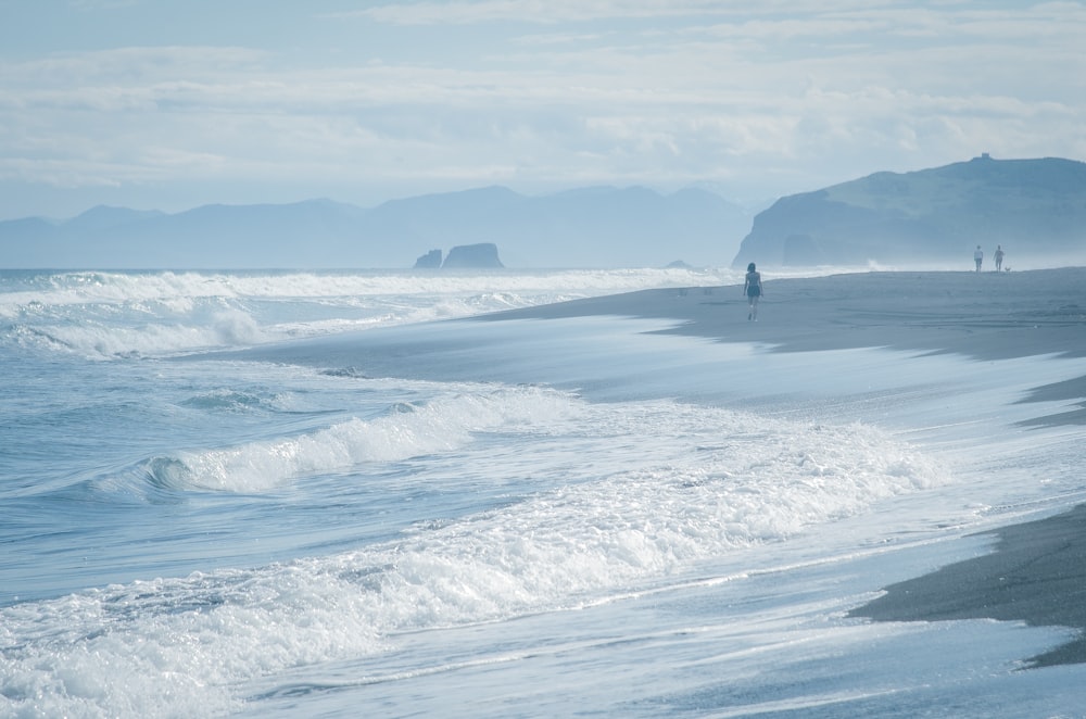 a person walking along a beach near the ocean