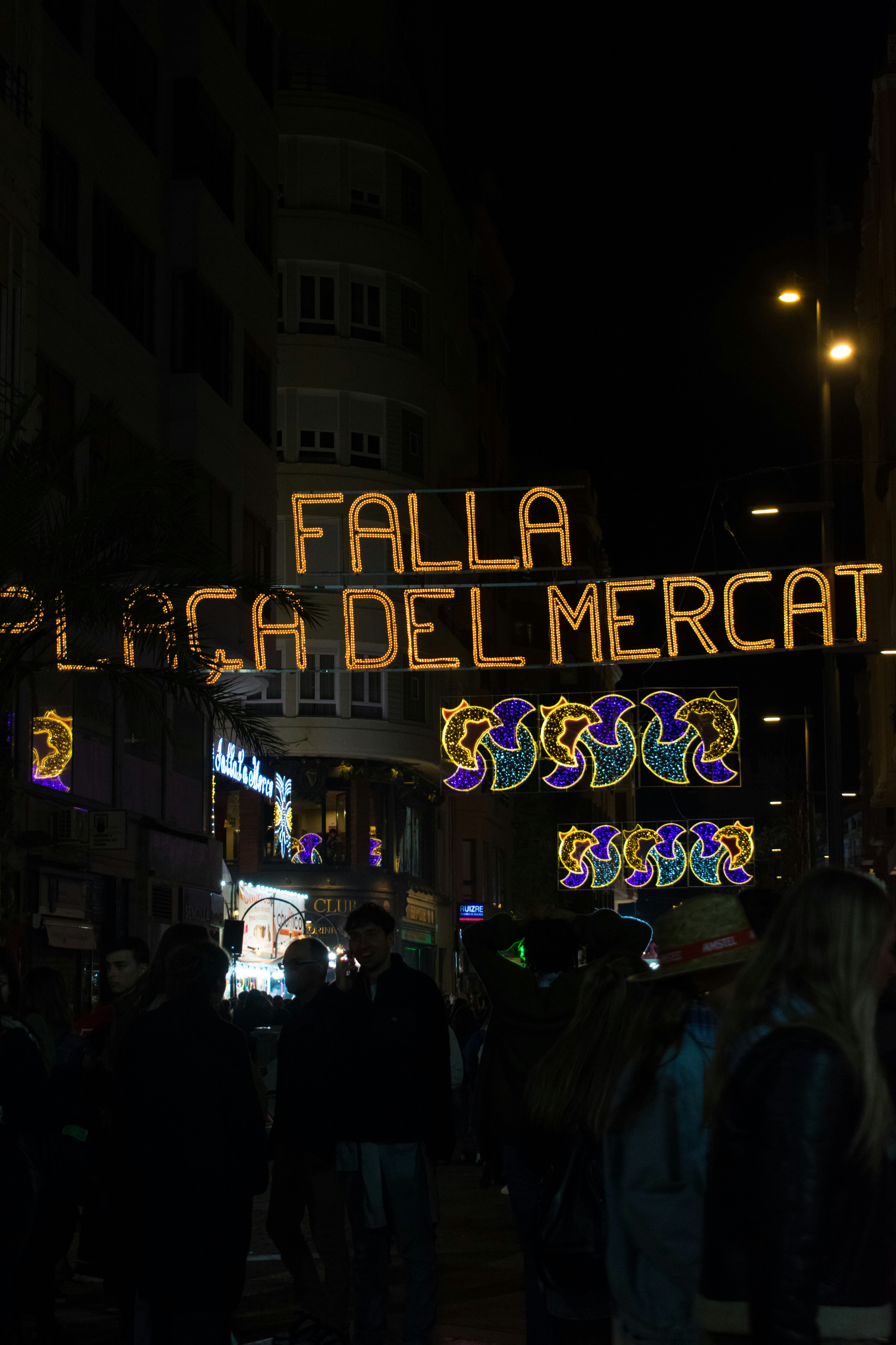 a group of people walking down a street at night