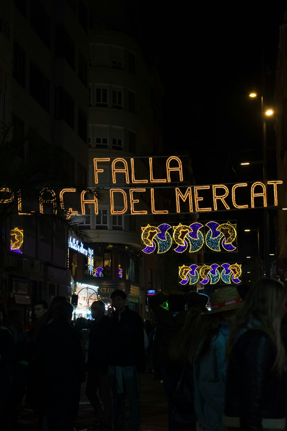 a group of people walking down a street at night