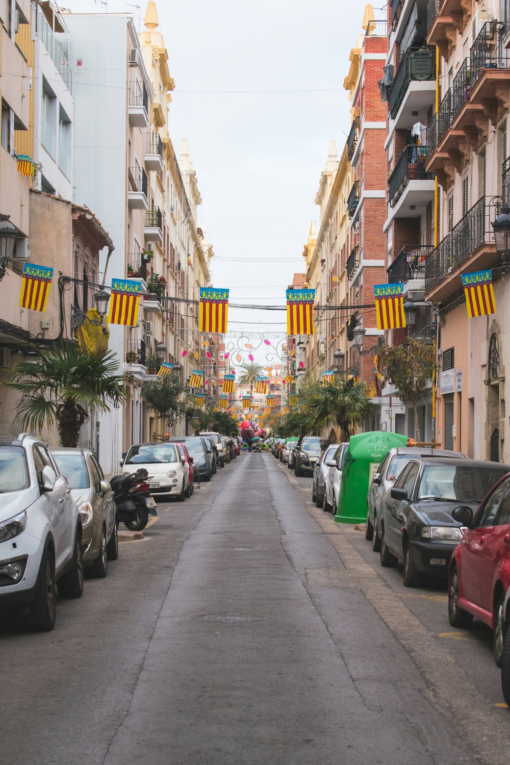 a street lined with parked cars next to tall buildings