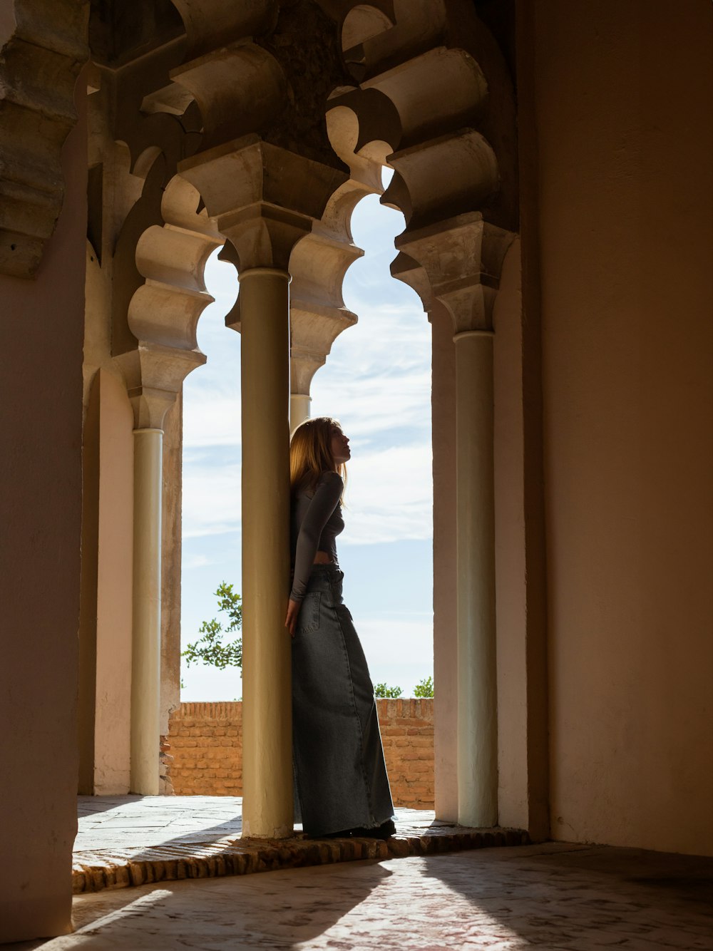 a woman in a long dress standing in an archway