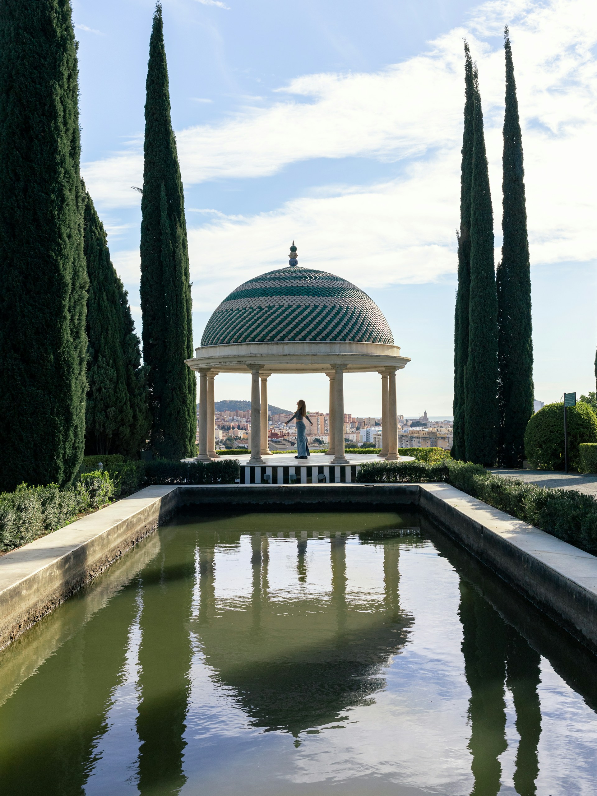 a gazebo surrounded by trees and water in a park