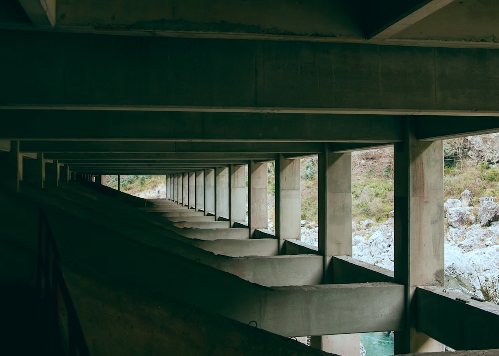 a row of concrete benches sitting under a bridge