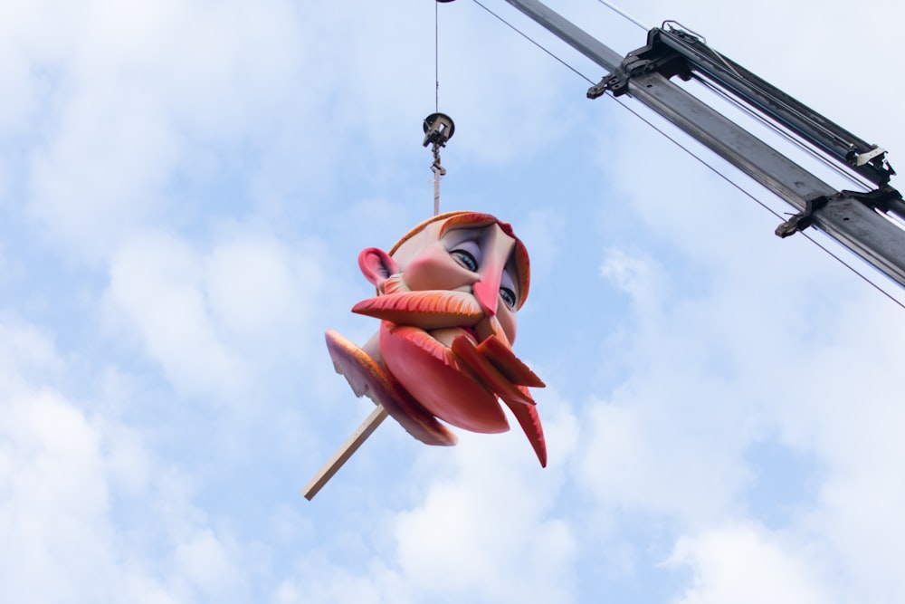 a sculpture of a woman hanging from a crane