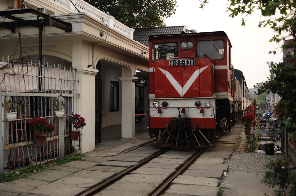 a red and white train parked at a train station