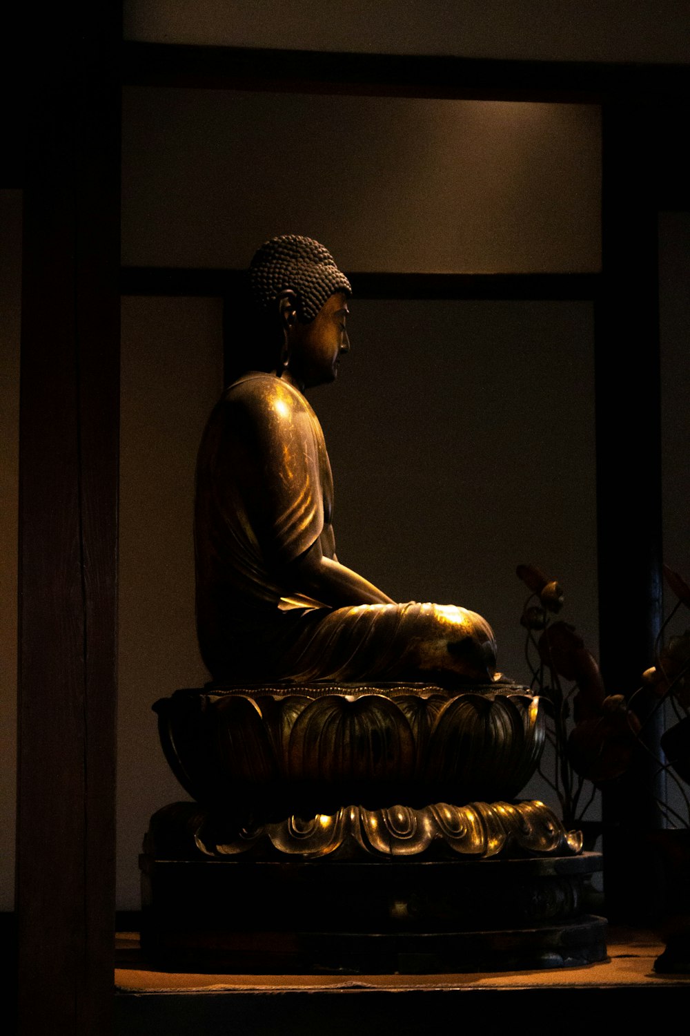 a buddha statue sitting in a dimly lit room