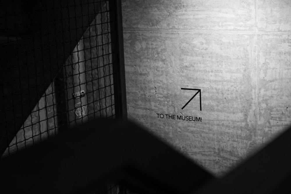 a black and white photo of a sign on a wall