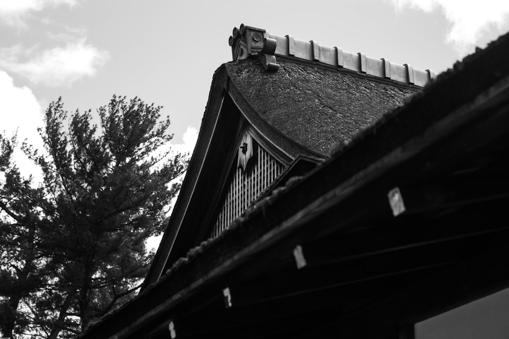 a black and white photo of a roof with a clock on it