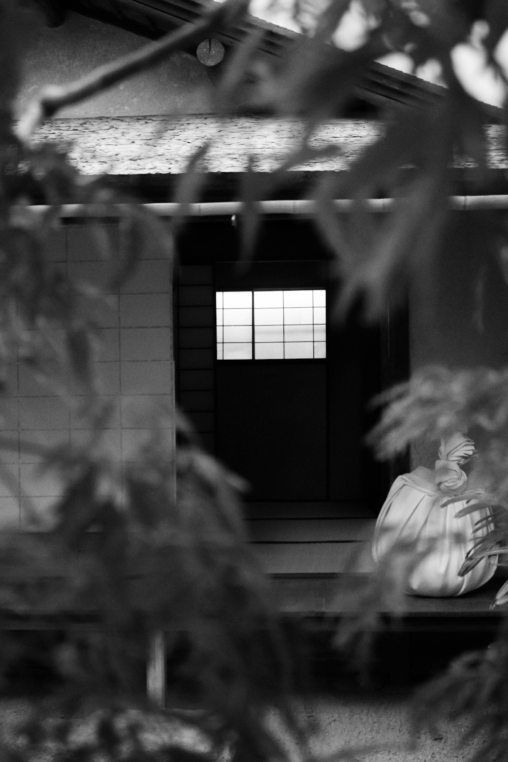 a black and white photo of a person sitting on a bench