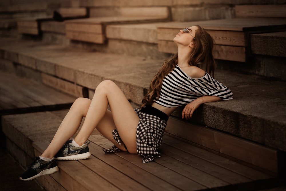 a woman is sitting on a wooden bench