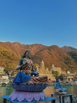 a statue of a woman sitting on top of a flower