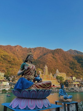 a statue of a woman sitting on top of a flower