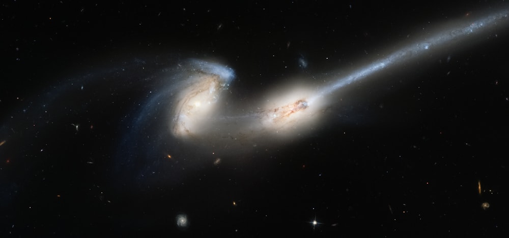 two spiral galaxy like objects in the dark sky