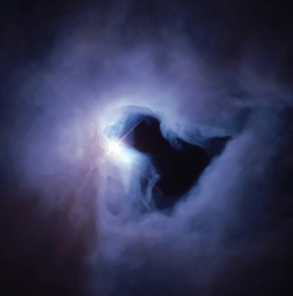 a black hole in the middle of a cloud of smoke