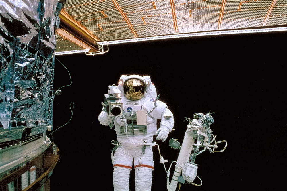 우주복을 입은 남자가 우주정거장 옆에 서 있다