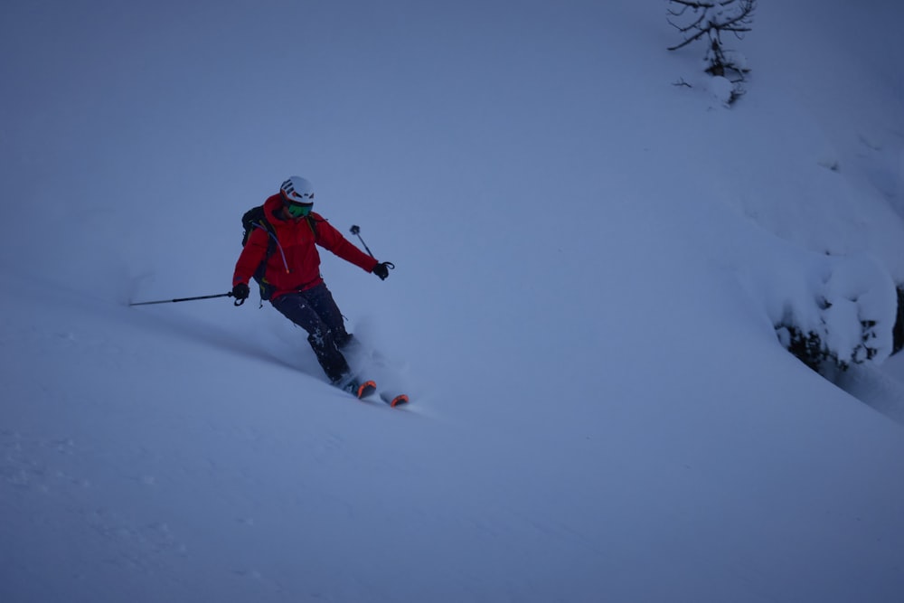 a man riding skis down a snow covered slope