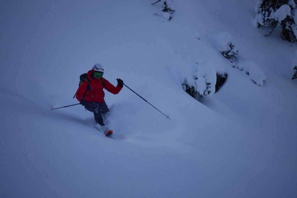 a man riding skis down a snow covered slope