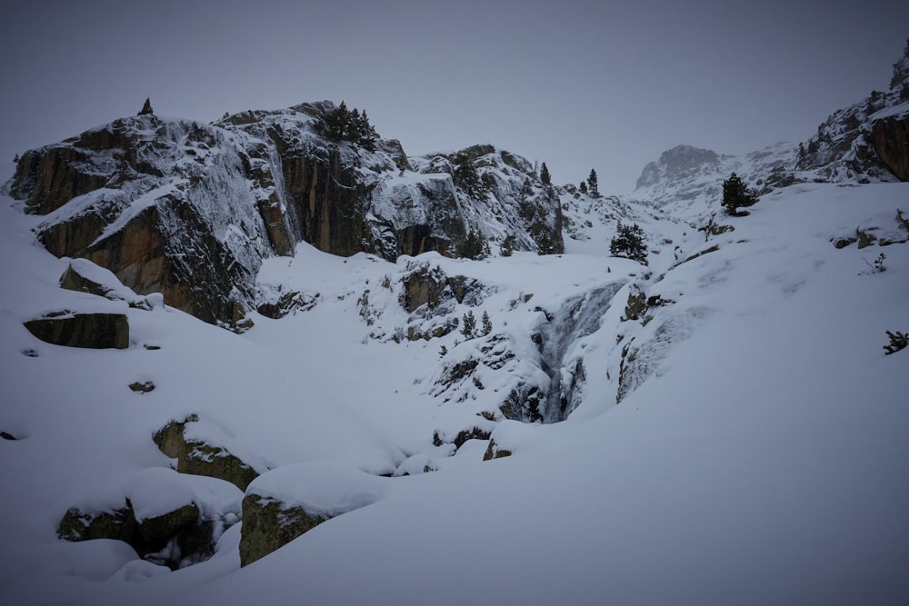 a snow covered mountain with a small waterfall