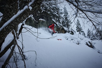a man riding a snowboard down a snow covered slope