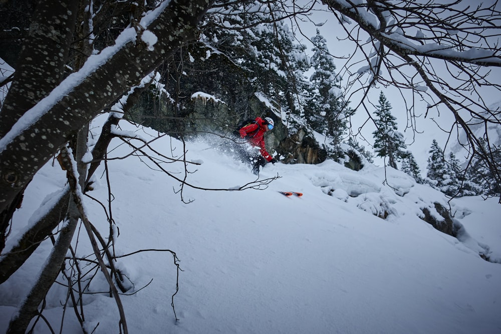 a man riding a snowboard down a snow covered slope