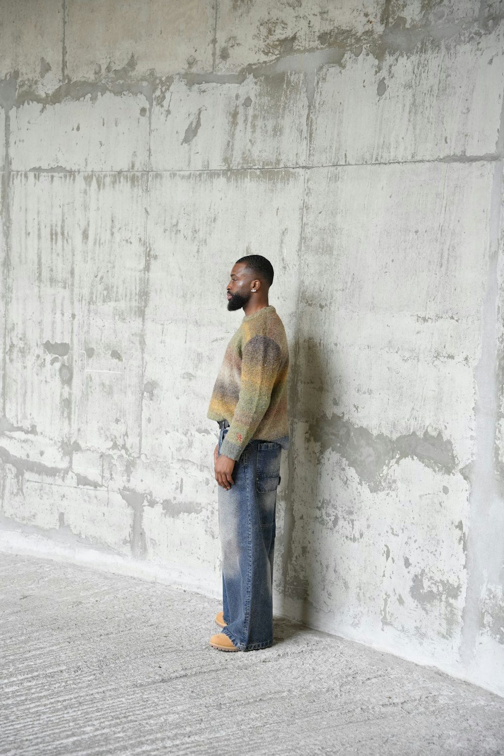 a man standing in front of a concrete wall