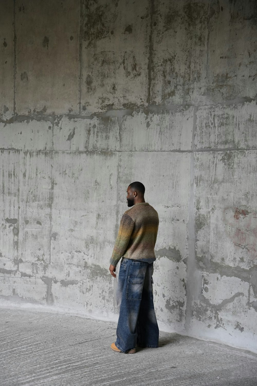 a man standing in front of a concrete wall