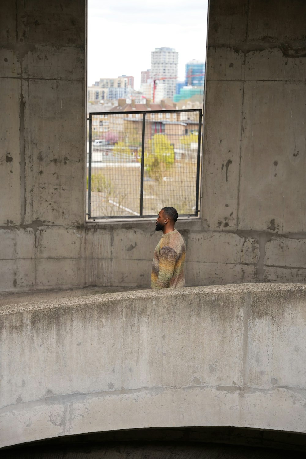 a person sitting on a ledge looking out a window