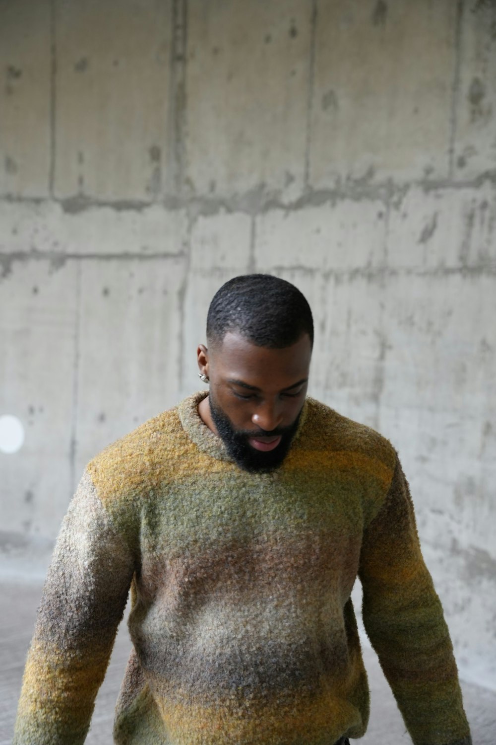 a man with a beard wearing a multicolored sweater