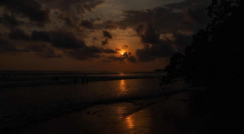 Il sole sta tramontando sull'acqua in spiaggia