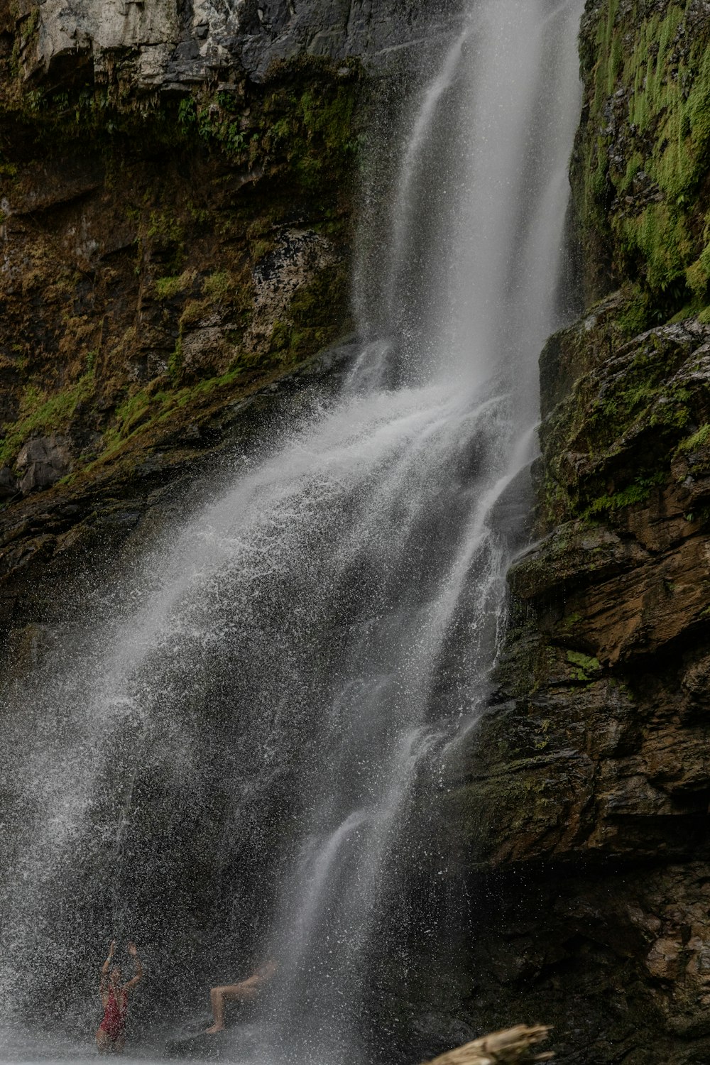 une personne debout devant une chute d’eau