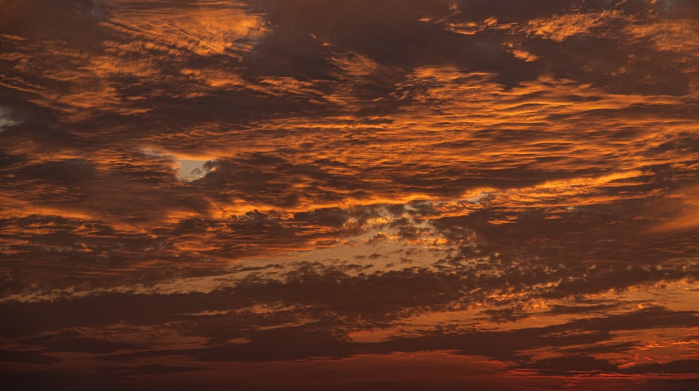 a plane flying in the sky at sunset