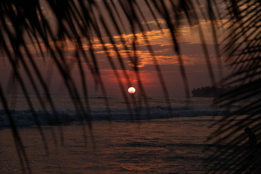 Le soleil se couche sur l’océan avec des vagues