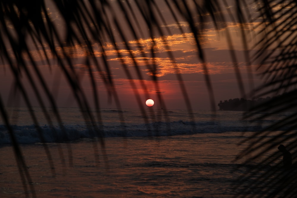 the sun is setting over the ocean with waves