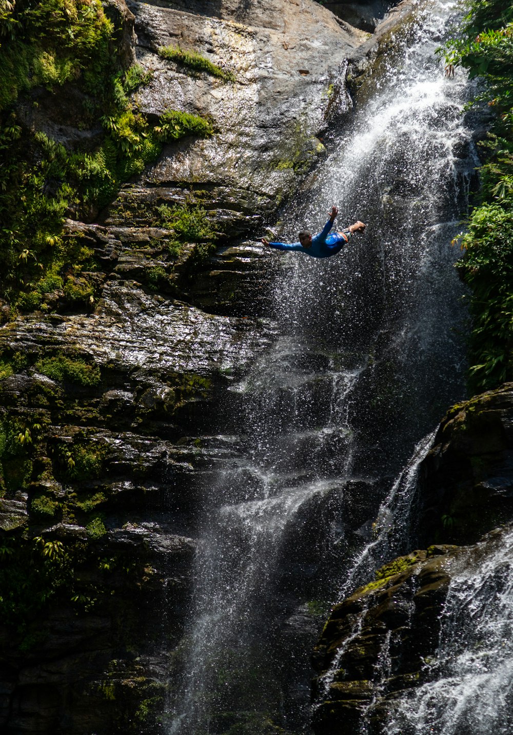 a man falling off of a waterfall into a body of water