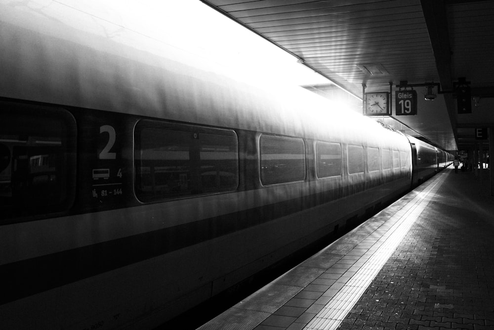 uma foto em preto e branco de um trem em uma estação de trem