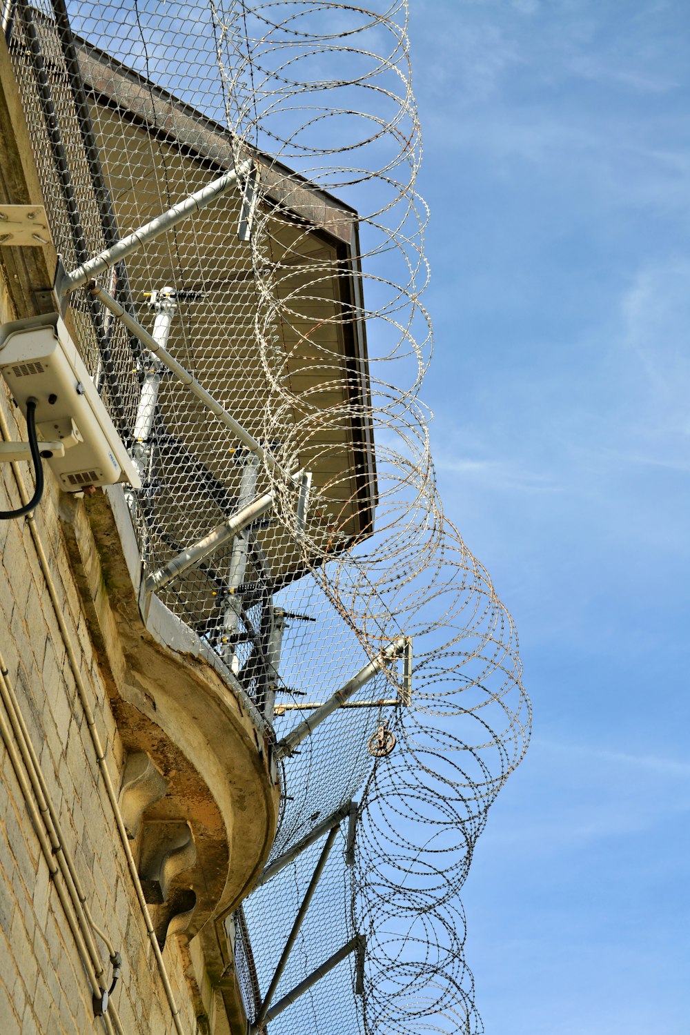 a tall building with a bunch of barbed wire on top of it