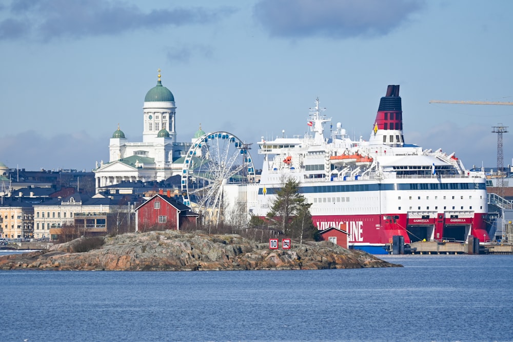 a large cruise ship in a harbor with a city in the background