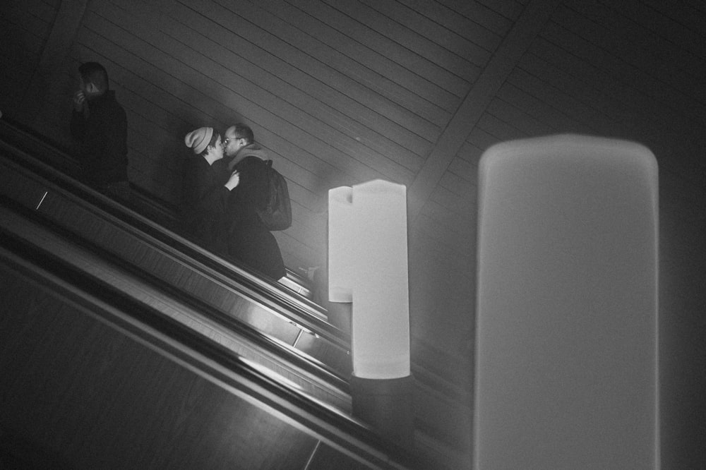 a couple of people riding down an escalator