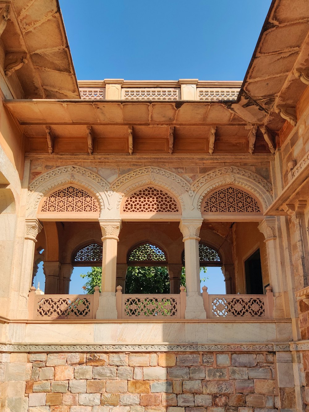 a stone building with arches and a balcony