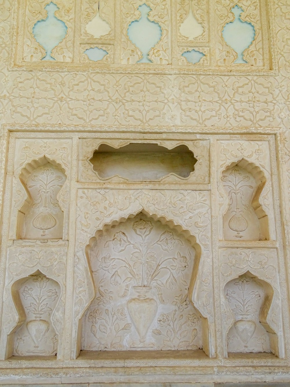 a white wall with carvings on the side of it