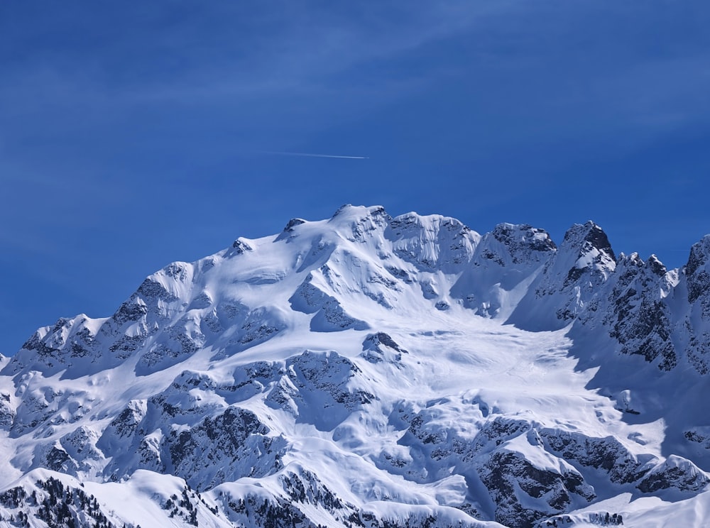 a mountain covered in snow under a blue sky