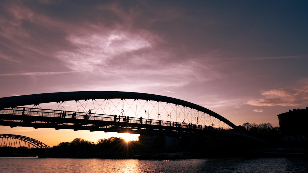 a bridge over a body of water at sunset