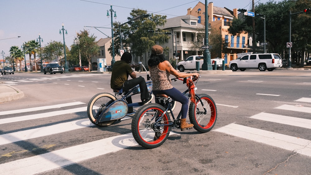 a couple of people riding bikes down a street