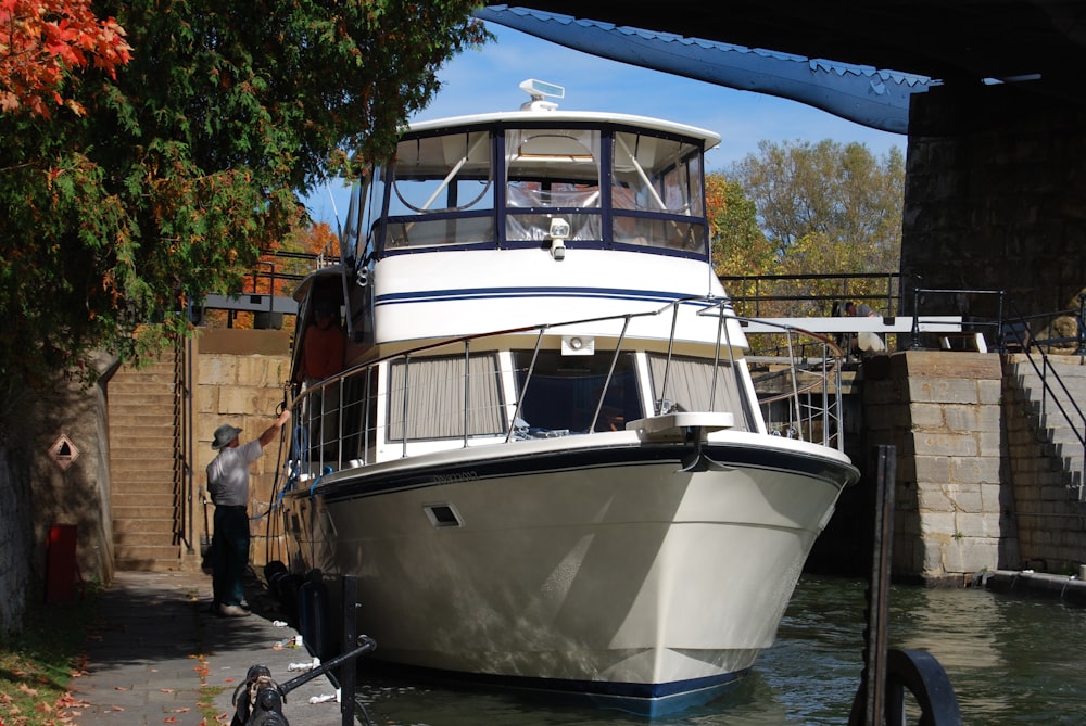 a white boat is docked at a dock