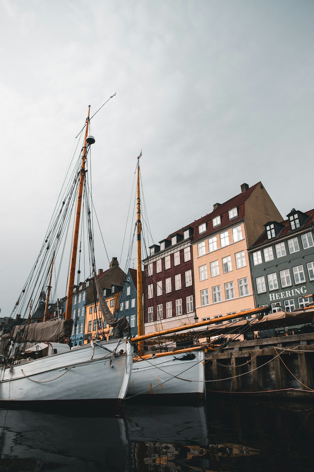 a sailboat docked in a harbor with buildings in the background