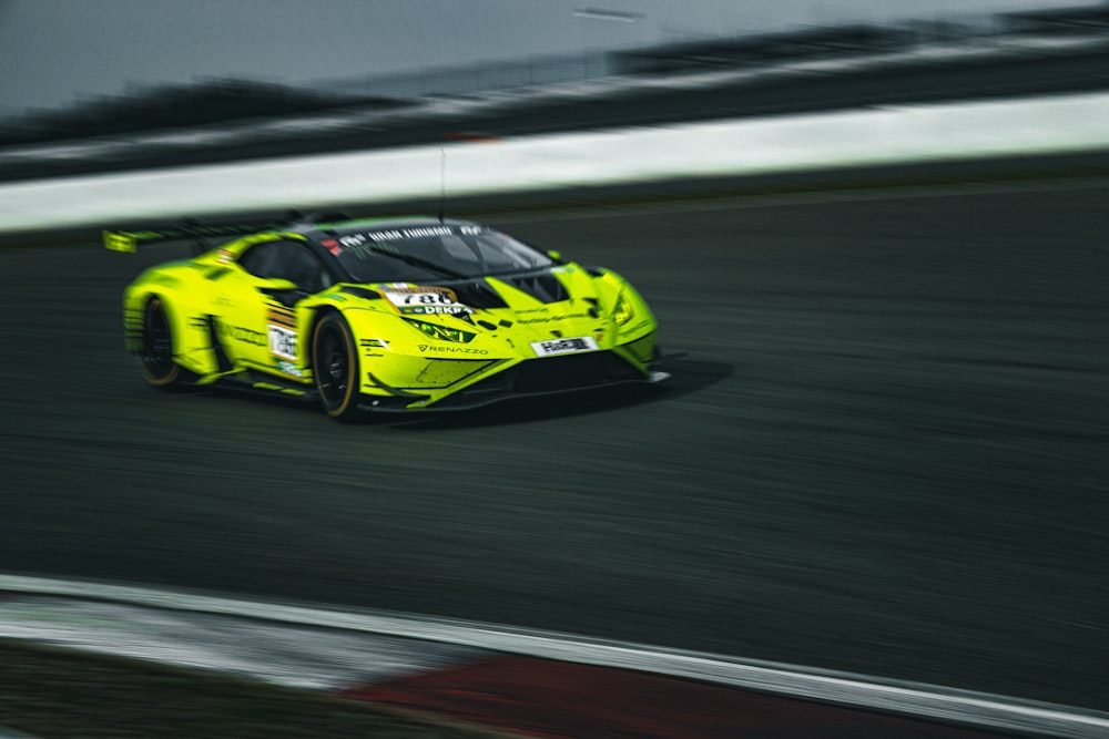 a yellow sports car driving on a race track